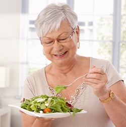 Senior woman eating salad at home