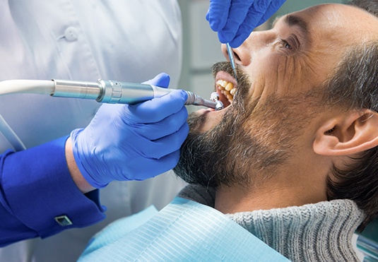A middle-aged man receiving a dental cleaning