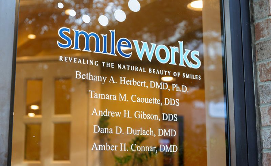 Glass door with Smileworks logo and names of dentists