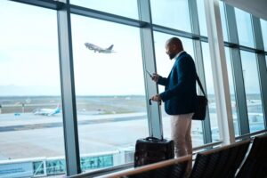 a man using his phone and waiting at an airport