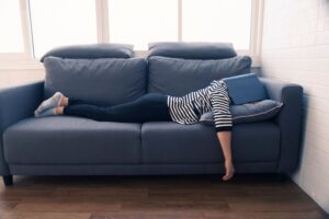 Woman napping on sofa with her book 
