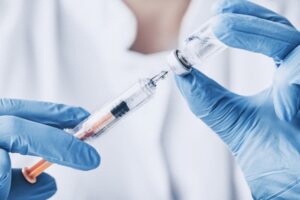 Gloved hands preparing BOTOX injection